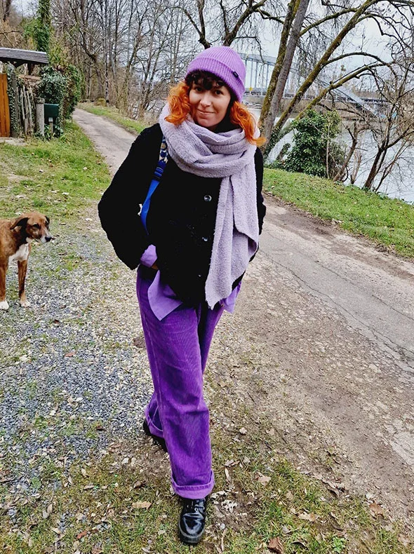 Une femme aux habits violet marchant dans la nature